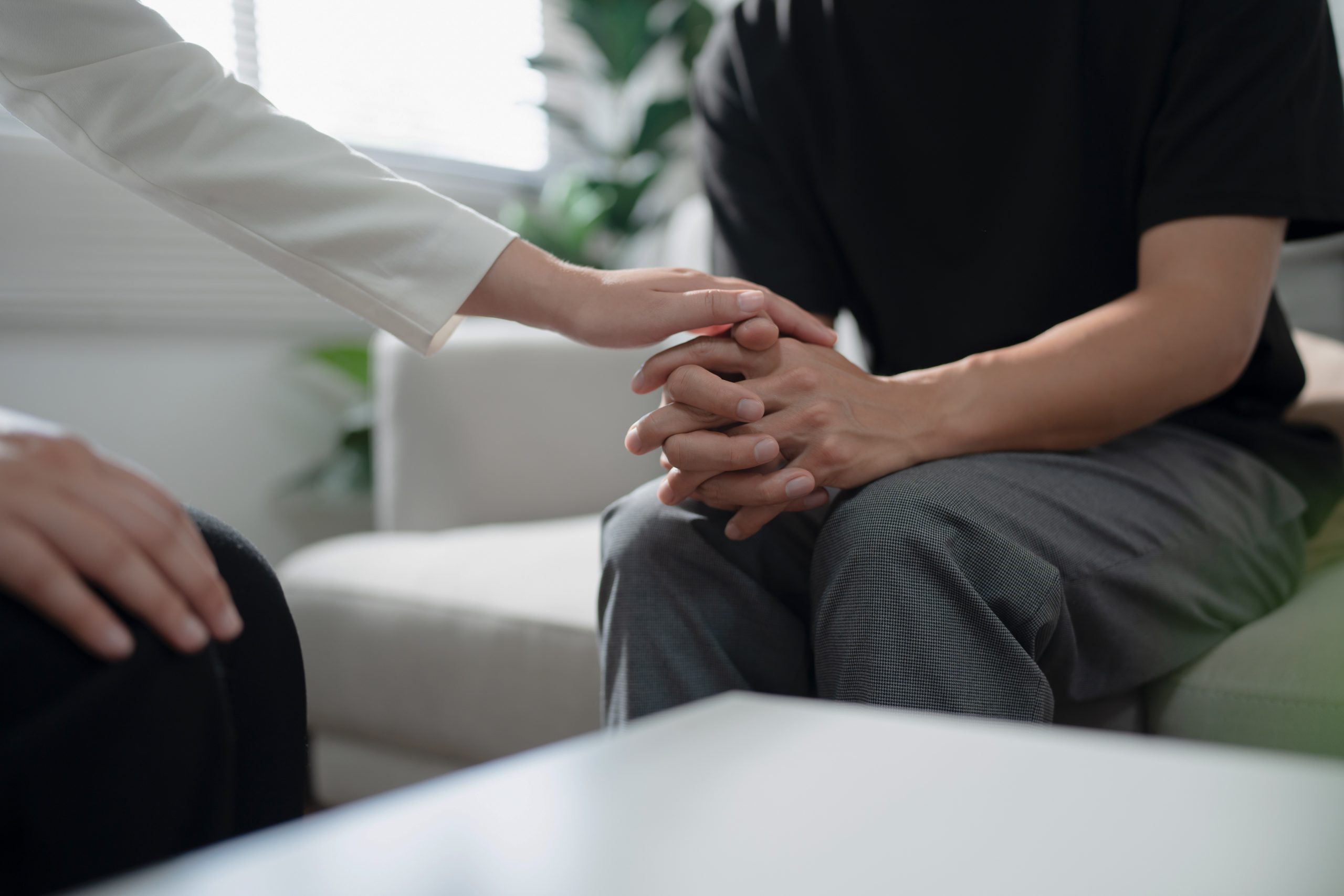 Individual receiving grief counselling from a therapist showing comfort